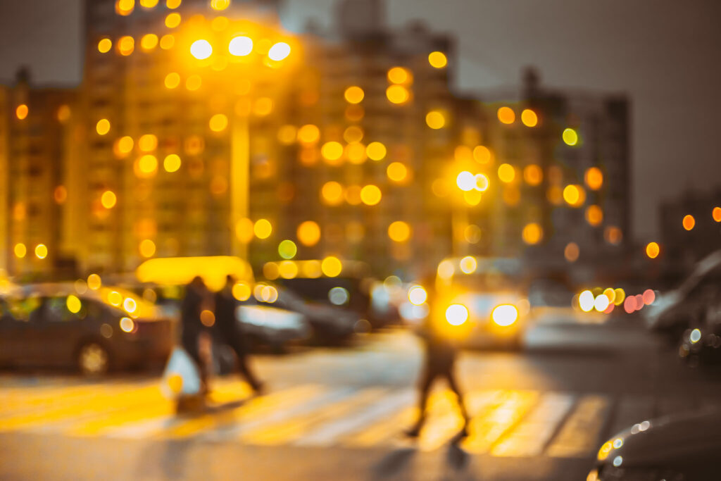 Pedestrians crossing a city street at night